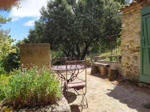 un patio con mesa y sillas en un jardín en Sous les Chênes, en Peypin-dʼAigues