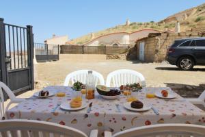 una mesa con platos de comida y una botella de vino en Casa Cueva Bella Vista, en Alcudia de Guadix
