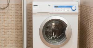 a washing machine in a bathroom with a brick wall at APPARTAMENTO LA CAFFETTERIA in Rovereto