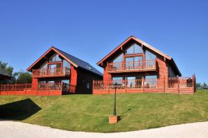 a large house with a large deck on the grass at Trevone House with Hot Tub on Retallack Resort in Padstow