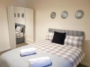 1 dormitorio con 1 cama con 2 toallas en Cosy 2 Bedroom Family Home In Glasgow City, en Glasgow