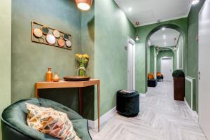 a hallway with green walls and a chair and a table at Ripetta Natural Suites in Rome