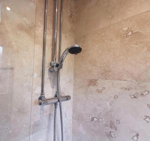a shower with a shower head in a bathroom at Cosy 2 Bedroom Family Home In Glasgow City in Glasgow