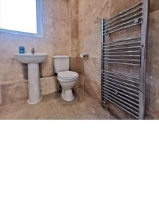 a bathroom with a toilet and a sink at Cosy 2 Bedroom Family Home In Glasgow City in Glasgow