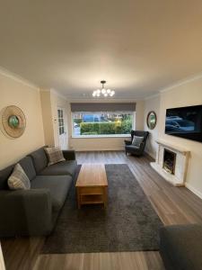 a living room with a couch and a fireplace at Cosy 2 Bedroom Family Home In Glasgow City in Glasgow