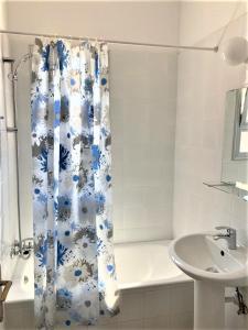 a bathroom with a blue and white shower curtain and a sink at Ariadne Apartments in Paphos City