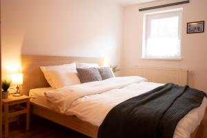 Apartments Pod Bregom في كراجسكا غورا: غرفة نوم بها سرير أبيض كبير مع نافذة +12 صورة