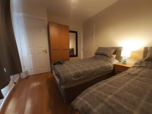 a bedroom with two beds and a lamp on a table at Carvetii - Xavier House - 2-storey sleeps up to 7 in Rosyth