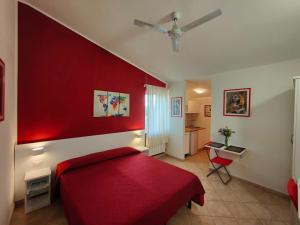 a bedroom with a red wall and a red bed at Gullo Capo Vaticano in Ricadi