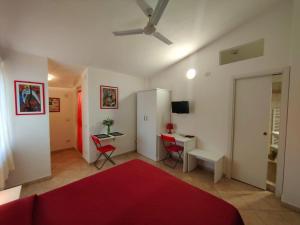 sala de estar con cama roja y escritorio en Gullo Capo Vaticano en Ricadi