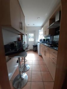 uma cozinha com armários brancos e piso em azulejo em Carvetii - Xavier House - 2-storey sleeps up to 7 em Rosyth