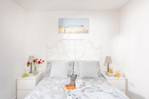 Un dormitorio con una cama blanca con una calabaza. en Wheal Jewel- Beautifully Fitted Wooden Lodge Helston Cornwall en Helston