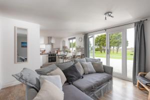 sala de estar con sofá gris y cocina en Wheal Jewel- Beautifully Fitted Wooden Lodge Helston Cornwall en Helston