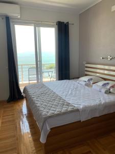 una camera da letto con un grande letto con una grande finestra di Sunrise Apartments and Studios a Star Dojran