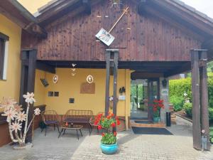 um edifício de madeira com uma mesa, cadeiras e flores em Pension Eichhorn em Bayerisch Eisenstein