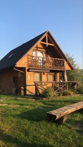 una grande casa in legno con balcone e panca di Osada Ostoja a Radziejowa