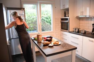 Eine Frau in einer Küche, die in einen Kühlschrank schaut. in der Unterkunft Villa Monte Kariotes in Samothráki
