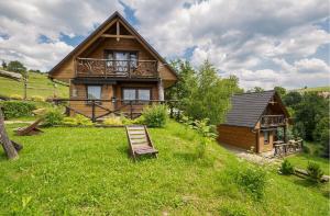a wooden house with a bench in the grass at Osada Ostoja in Radziejowa