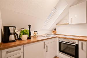 a kitchen with white cabinets and a sink at Ferien-Apartment Haubentaucher im Naturschutzgebiet mit Privatstrand in Friedrichshafen