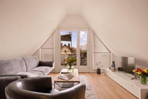 a living room with a couch and a tv at Ferien-Apartment Haubentaucher - mit priv Strandzugang in Friedrichshafen