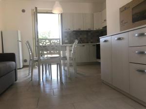 een keuken met een tafel en stoelen in een kamer bij Calanovella Mare piano terra 5 in Piraino