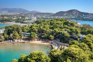 eine Luftansicht auf einen Strand mit Bäumen und Wasser in der Unterkunft Four Seasons Astir Palace Hotel Athens in Athen