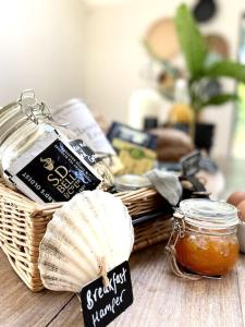 a basket of food and a jar of honey on a table at 'The Studio' Designer, seaside cottage in Crawfordsburn