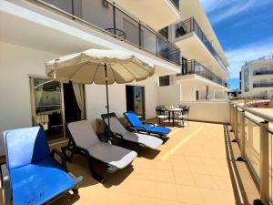 - Balcón con sillas, sombrilla y mesa en Albufeira Terrace With Pool by Homing, en Albufeira