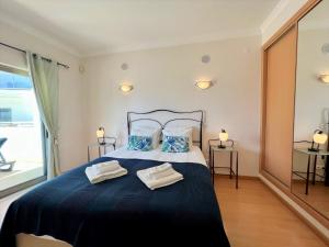 Un dormitorio con una cama grande con dos toallas encima. en Albufeira Terrace With Pool by Homing, en Albufeira