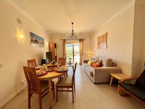 una sala de estar con una mesa y un sofá en Albufeira Terrace With Pool by Homing, en Albufeira