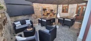 a patio with tables and chairs and an umbrella at Casa Dos Ruis - Turismo Rural in Tabuaço