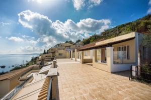 a balcony of a house with a view of the water at El Greco hotel by Estia in Benitses