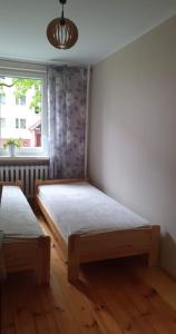 a bedroom with two beds and a window at Apartament 5 minut spacerem od plaży in Giżycko