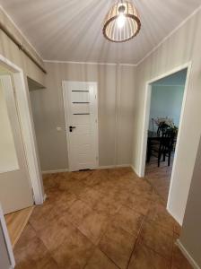 an empty living room with a door and a table at Apartament 5 minut spacerem od plaży in Giżycko