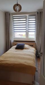 a bedroom with a bed with a blue pillow on it at Apartament 5 minut spacerem od plaży in Giżycko +2 photos