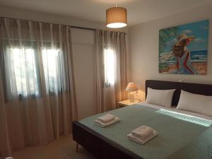 een slaapkamer met een bed met twee handdoeken erop bij Sea melody apartments in Stavromenos