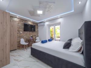 a bedroom with a large bed and a tv on a brick wall at Casa di Fratelli in Budva