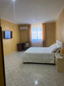 a bedroom with a bed and a desk and a television at Armonia B&B in Aquino