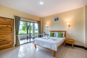 a bedroom with a bed and a sliding glass door at Tontan Resort Cha-am in Cha Am Beach +45 photos