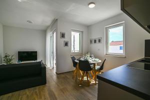a kitchen and living room with a table and chairs at Apartment Perlitto in Cres
