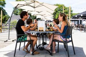 eine Gruppe von Menschen, die an einem Tisch sitzen in der Unterkunft EuroParcs Limburg in Susteren