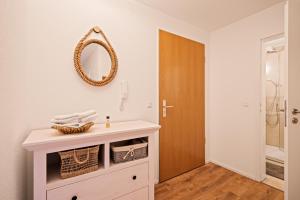 a bathroom with a sink and a mirror on the wall at Ferien-Apartment Auenwald - mit priv Strandzugang in Friedrichshafen