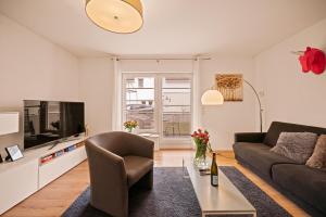 a living room with a couch and a tv at Ferien-Apartment Auenwald - mit priv Strandzugang in Friedrichshafen