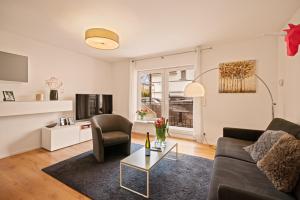 a living room with a couch and a table at Ferien-Apartment Auenwald - mit priv Strandzugang in Friedrichshafen