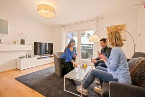 a group of people sitting in a living room at Ferien-Apartment Auenwald - mit priv Strandzugang in Friedrichshafen