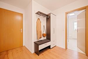 Zimmer mit einem Schrank mit einer Bank in der Unterkunft Wohlfühl-Apartment Auenwald im Naturschutzgebiet mit Privatstrand in Friedrichshafen