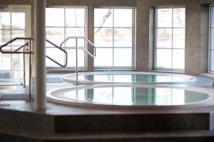 una grande piscina d'acqua in una stanza con finestre di Gränsö Slott Hotel & Spa a Västervik