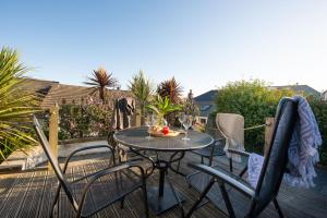 a table and chairs on a patio with a bowl of fruit at Eastleigh Cottage, Marazion in Marazion
