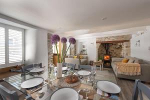 a dining room and living room with a table and chairs at Eastleigh Cottage, Marazion in Marazion