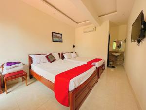 a bedroom with a large bed with a red blanket at Windy River Homestay in Hoi An
